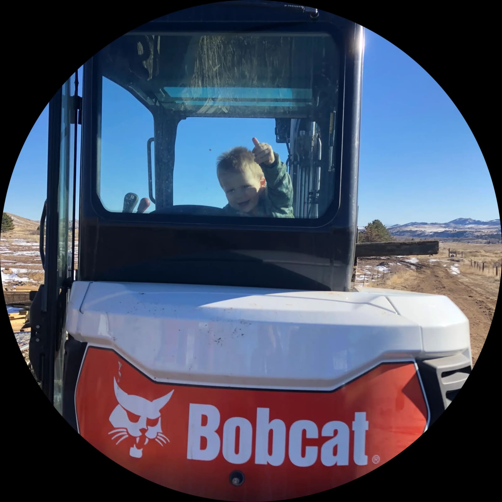 A young Rock Solid family member giving a thumbs-up from company equipment